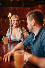 Drunk man with beer mug and waitress at counter