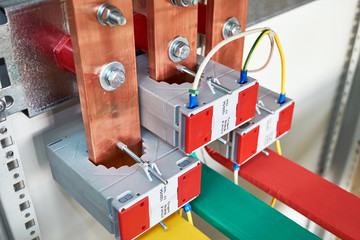 Electrical current transformers fitted on vertical copper busbars. Electrical wires are connected...