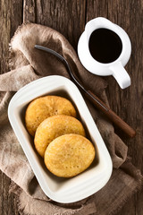 Chilean Sopaipilla nortena deep-fried pumpkin pastry with sweet chancaca raw cane sugar sauce, popular snack in autumn and winter, photographed overhead (Selective Focus, Focus on the food)
