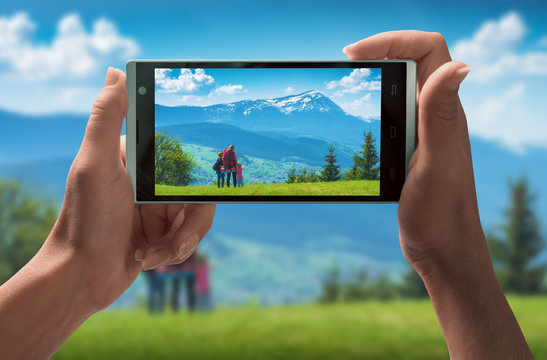 Active family in a mountains on smartphone screen