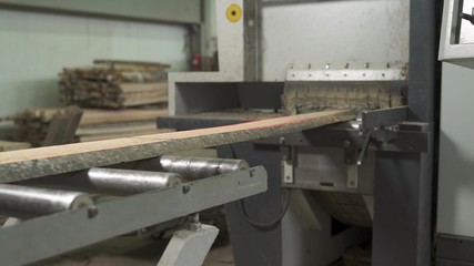 A close-up of a wooden workpiece moving on industrial conveyor belt