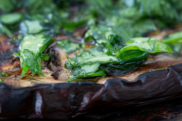 Close up of a slice of grilled aubergine with parsley.