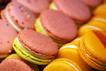 Fototapeta na wymiar Colorful macaroons close-up. Pink and orange almond cookies with filling, sweet background