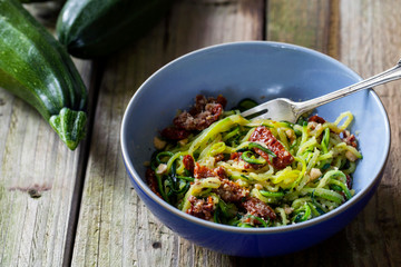 Courgette spaghetti with sun dried tomatoes and mince hazelnuts - obrazy, fototapety, plakaty