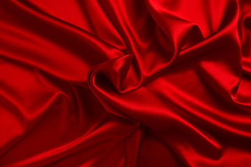 Red silk or satin luxury fabric texture can use as abstract background. Top view.