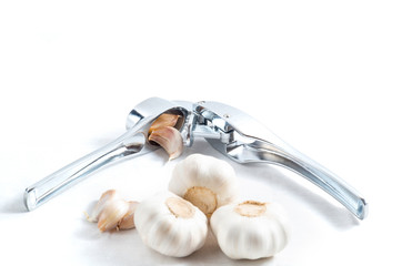 Garlic press and garlic isolated on white closeup