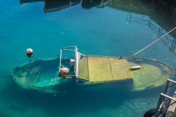 A sunken fisherman's boat, among the colorful variety of boats and ships fill the docks of the harbors of Syracuse (Siracusa), a historic city on the island of Sicily, Italy.