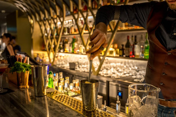 Obraz premium Barman preparing cocktails. Picture with blurry bar environment in the background.