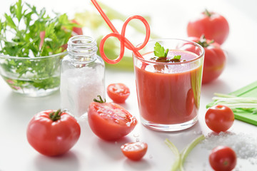 Tomato juice in glass with celery, cherry tomato, white wood background, closeup