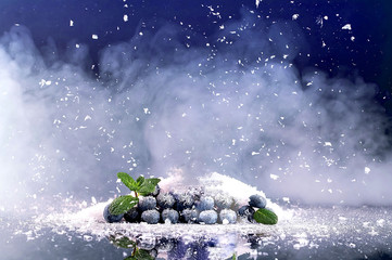 Blueberries on background of snow and smoke. 