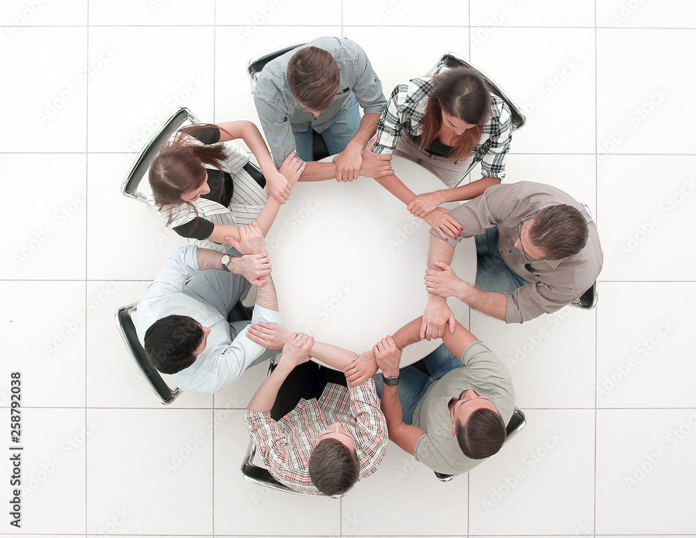 Wall mural top view.the business team hold hands, forming a circle