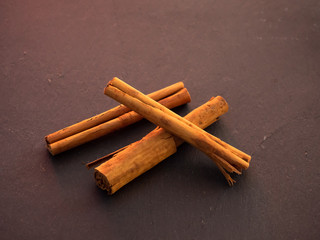 Several dried cinnamon sticks on a slate plate