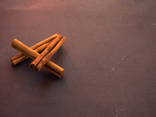 Several dried cinnamon sticks on a slate plate
