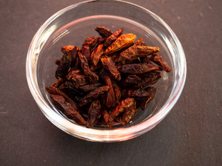 A glass bowl with spicy cayenne on a slate plate