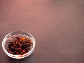 A glass bowl with spicy cayenne on a slate plate