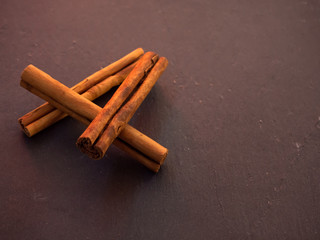 Several dried cinnamon sticks on a slate plate