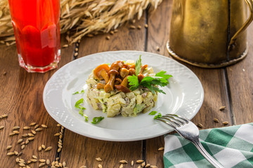 salad with honey agaric and potato on wooden table