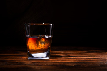 glass of whiskey or cognac on a wooden background