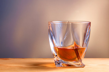 glass of whiskey or cognac on a wooden table