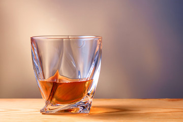 glass of whiskey or cognac on a wooden table