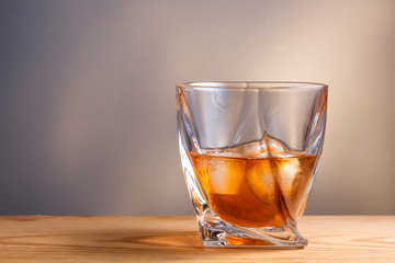 glass of whiskey or cognac over wooden table
