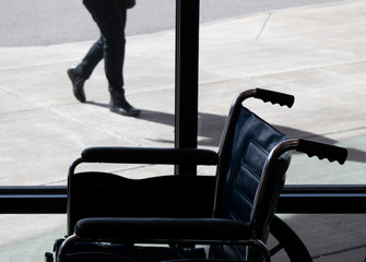Wheelchair indoors with person walking outside