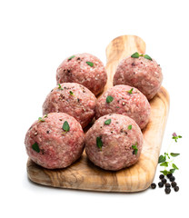 Raw meat balls on wooden cutting board isolated on white