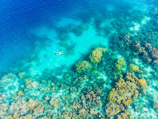 Naklejka na ściany i meble Aerial top down people snorkeling on coral reef tropical caribbean sea, turquoise blue water. Indonesia Banyak Islands Sumatra, tourist diving travel destination.