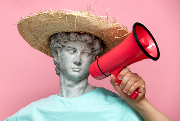 Antique bust of male in hat with red megaphone on pink background