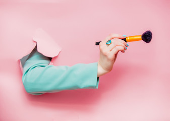 Female hand in classic blue jacket with visage brush