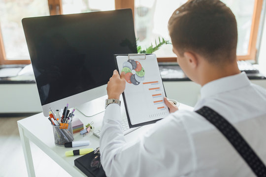 Focus at the businessman, he is looking at diagrame at office.