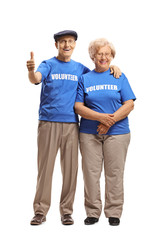 Senior volunteers smiling at the camera and giving thumbs up