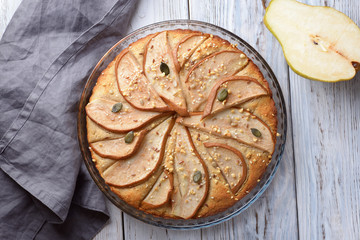 gorgeous pie with pears in a glass container on wooden background