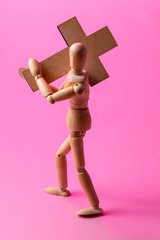 Wooden man. A wooden man holds a cross. Cross. Cross in hand.