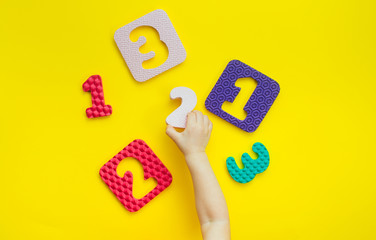 Kids hands playing with puzzles in a number shape