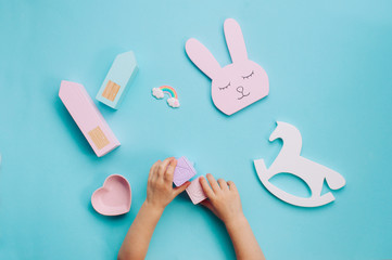 Kids hands playing with toys on blue background