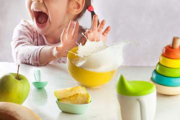 Little girl doesn't want to eat her breakfast porridge