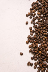 Roasted coffee beans in bulk on a light pink background. dark cofee roasted grain flavor aroma cafe, natural coffe shop background, top view from above, copy space