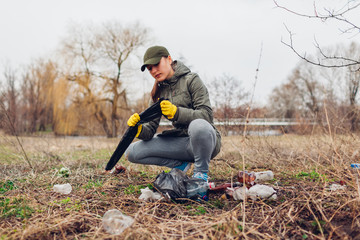 Woman volunteer cleaning up the trash in park. Picking up litter outdoors. Ecology and environment...