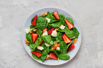 Fresh strawberry salad with spinach leaves, parmesan cheese and walnuts. healthy diet food