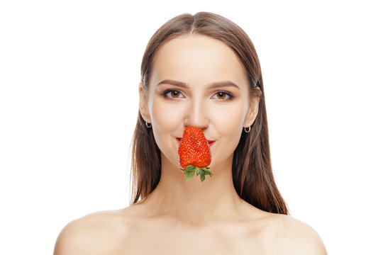 Beautiful happy girl with clean and healthy skin with strawberry near lips. Cosmetology , treatment, beauty and spa . Skin care and aromatherapy.