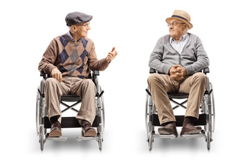 Obraz na płótnie Canvas Two senior men in wheelchairs having a conversation