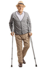 Senior man walking with crutches and smiling at the camera