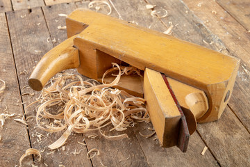 Old planer on a wooden carpentry table. DIY accessories in an old workshop.