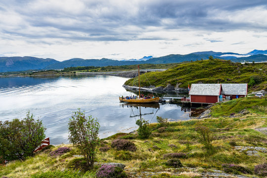 Traditional wooden ship entering in a small port near the iconic Atlantic Road. Karvag, Averoy, More og Romsdal, Norway, August 2018