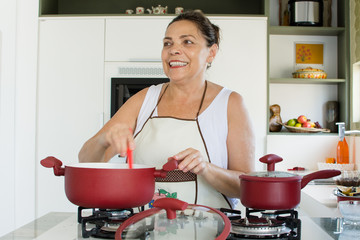 Mulher cozinhando feliz com panelas