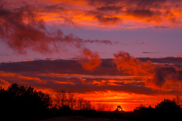 Fiery orange sunset  colorful and speckled  clouds.