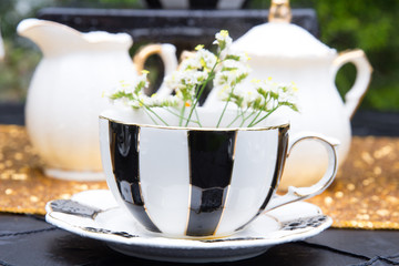 Gold glitter and black and white striped tea pots and tea cups at a tea party