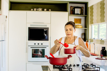 Mulher cozinhando feliz com panelas