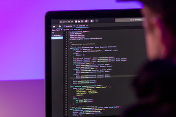 Programmer working on laptop computer in office